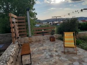 a couple of chairs sitting on a stone patio at Apartment Matija in Stara Novalja