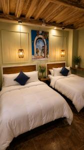 two beds in a room with white sheets at Maloka Boutique Centro Histórico in Cartagena de Indias +60 photos