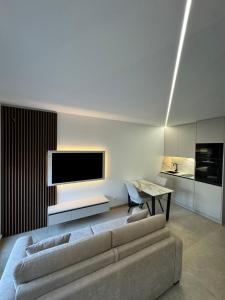 a living room with a couch and a flat screen tv at Esch City Studio in Esch-sur-Alzette