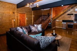 a living room with a leather couch and a table at 56 Crocodile in Komatipoort