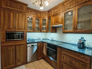 a kitchen with wooden cabinets and blue counter tops at Napsugár Vendégház Velence in Velence +16 photos
