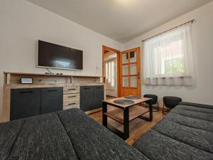 a bedroom with a bed and a tv on the wall at Napsugár Vendégház Velence in Velence