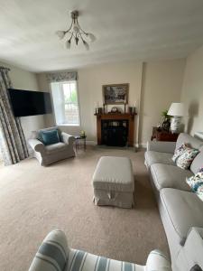 a living room with two couches and a table at Dale Grange in Askrigg
