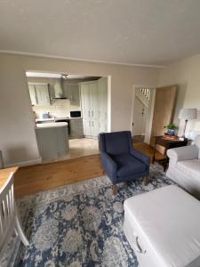 a living room with a blue chair and a couch at Dale Grange in Askrigg +32 photos