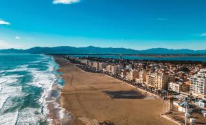 an aerial view of a beach with buildings and the ocean at Hôtel le Canetois in Canet-en-Roussillon