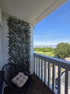a balcony with a chair and a wall with a view at Lake Breeze Stay in Liepāja +22 photos