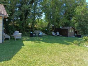 a yard with chairs and a table and a shed at Le Petit Manoir Vaillac in Fonmourenne +27 photos