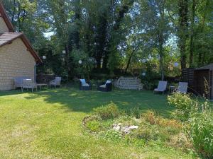 a group of chairs sitting in a yard at Le Petit Manoir Vaillac in Fonmourenne