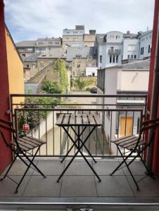 a balcony with two chairs and a view of a city at Esch City Studio in Esch-sur-Alzette