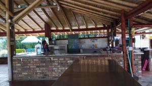 an outdoor kitchen with a counter and a table at Hotel El Gran Chaparral in Calarcá