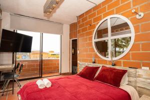 a bedroom with a large red bed and a mirror at Hotel Alto lindo in Guatapé