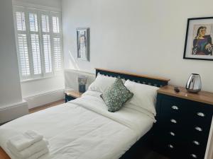 a bedroom with a bed with white sheets and pillows at Venue Apartment in Colne