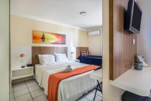 a hotel room with a bed and a tv at Mar de Ponta Negra in Natal +33 photos