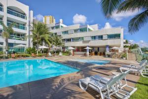 a swimming pool in front of a building at Mar de Ponta Negra in Natal