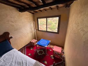 a room with a bed and a table and a window at Adrar view lodge in Imlil