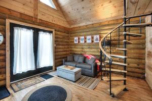 a living room with a staircase in a log cabin at Log cabin with SPA, pool, and small beach in Mont-Tremblant +22 photos