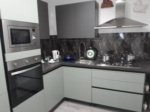 a kitchen with white cabinets and a stove and microwave at Case Quattro Venti in Chiesa Nuova