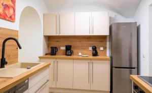 a kitchen with white cabinets and a stainless steel refrigerator at Ferienwohnung Mamma Rosa 1 in Wunsiedel