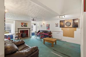 a living room with a leather couch and a table at Ghyllstead - North East Escapes in Glanton