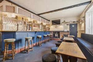 a bar with a row of tables and stools at Ghyllstead - North East Escapes in Glanton