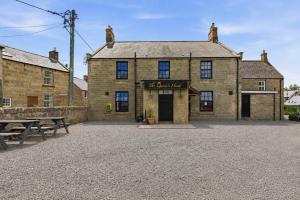 an old stone building with a picnic table in front of it at Ghyllstead - North East Escapes in Glanton