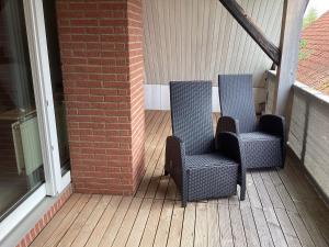 two chairs sitting on a porch next to a building at Storchennest im Leinetal in Einbeck