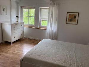 a bedroom with a bed and a dresser and a window at Storchennest im Leinetal in Einbeck