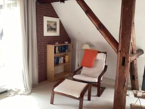 a living room with a chair and a book shelf at Storchennest im Leinetal in Einbeck