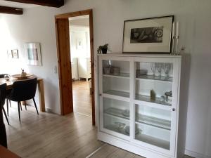 a white cabinet with glass shelves in a room at Storchennest im Leinetal in Einbeck
