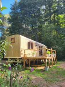 a rv parked in a yard with a wooden deck at Glamping Maringotka77 in Protivec