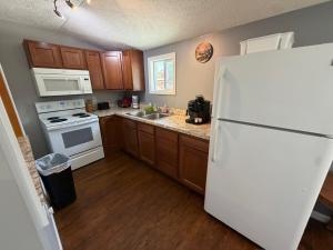 a kitchen with a white refrigerator and wooden cabinets at Strip Location Pet Friendly Fire Pit in Geneva