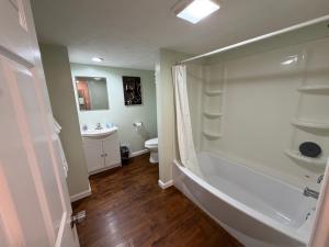 a bathroom with a tub and a toilet and a sink at Strip Location Pet Friendly Fire Pit in Geneva +20 photos