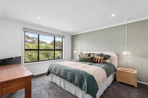 a bedroom with a bed and a large window at Chic coastal living in Anglesea