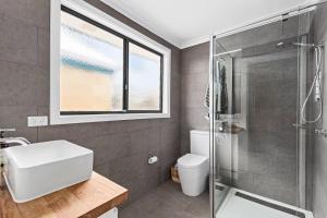 a bathroom with a shower and a toilet and a sink at Chic coastal living in Anglesea +6 photos
