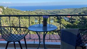 a table with two glasses of wine on a balcony at Anthoussa Rooms in Parga