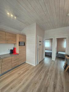 a large room with wooden floors and a kitchen and a room with beds at MORZA SZUM basen z podgrzewaną wodą, boisko, rowery in Sarbinowo