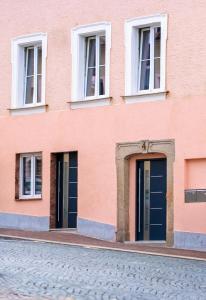 a pink building with windows and doors on a street at Ferienwohnung Mamma Rosa 1 in Wunsiedel
