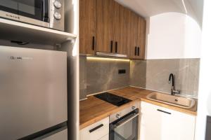 eine Küche mit einem weißen Kühlschrank und einer Spüle in der Unterkunft Bastasio Youth Studio in Thessaloniki + 43 Fotos