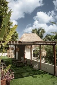 a patio of a house with a table and chairs at Hotel Lydna Ki'n in Bacalar