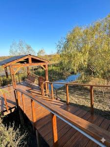 a wooden deck with a gazebo next to a river at Casa Sauce Delta in Tigre