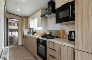 a kitchen with wooden cabinets and a stove at Hardy's Hut in Felton