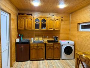a kitchen with wooden cabinets and a washing machine at Green house in Kutaisi +11 photos