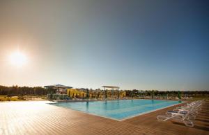 a large swimming pool with two lounge chairs next to it at CHARLOTTE STUDIOS BY BLAXY RESORT Olimp in Olimp +4 photos