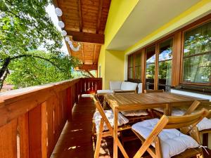 a porch with a wooden table and chairs at Julius Appartements & Zimmer in Wagrain