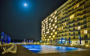 a large building with a pool in front of it at night at CHARLOTTE STUDIOS BY BLAXY RESORT Olimp in Olimp