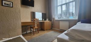 a bedroom with a bed and a desk with a computer at Skarb Morza in Międzyzdroje