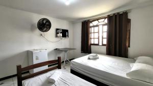 a bedroom with two beds and a window at Hotel Silveira in Guarapari