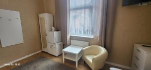 a kitchen with a chair and a white refrigerator at Skarb Morza in Międzyzdroje +23 photos