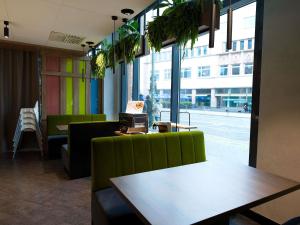 a restaurant with a table and a green couch at Novotel Suites Berlin City Potsdamer Platz in Berlin