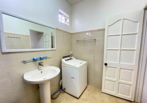 a bathroom with a sink and a toilet and a mirror at Beach Walk Apartment with Private Garden & Wifi in Grand-Baie +35 photos